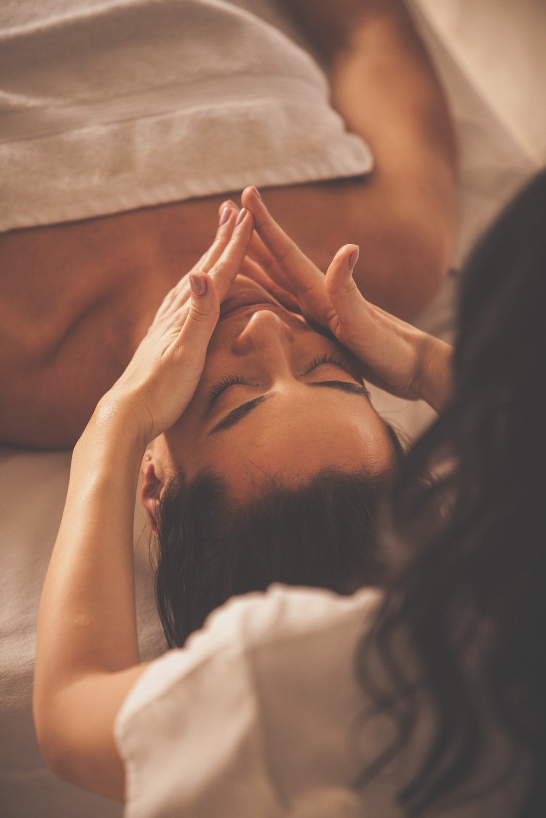 Woman enjoying facial massage at spa